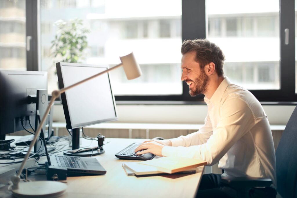 junger Mann arbeitet am Computer Büro Kunden gewinnen Das sind nützliche Werbemittel